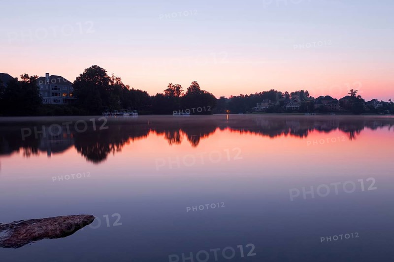 Lake landscape with houses. Misty sunrise