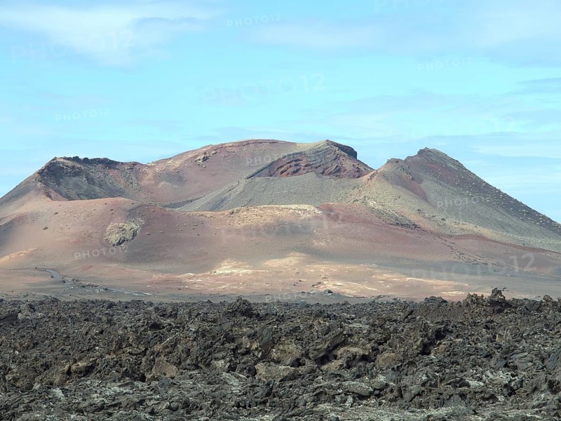 Close-up of a volcano and a lava field under a slightly cloudy sky on Lanzarote, arrecife, Lanzarote, Canary Islands, Spain, Europe