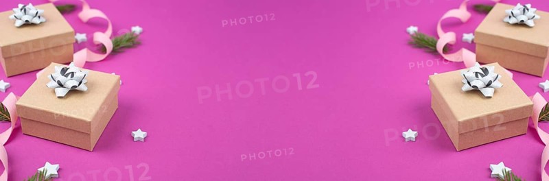 Christmas holiday background with little gift boxes, stars and fir branches, pink trendy background