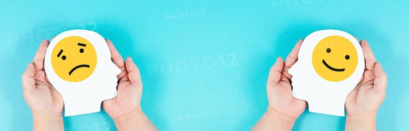 Holding a head with a sad and a happy face in the hands, mental health concept, positive and negative mindset, depression, support and evaluation symbol, emotion
