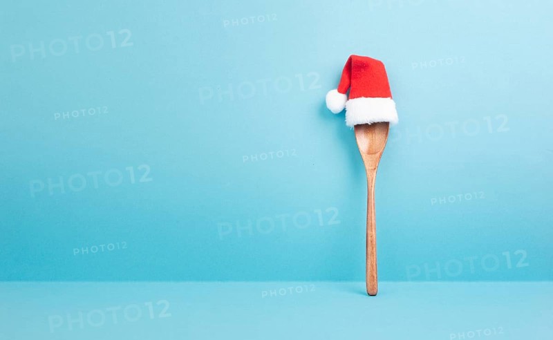 Blank paper with a wooden spoon and a red Santa Claus hat, christmas greeting card, copy space for a recipe for the holiday