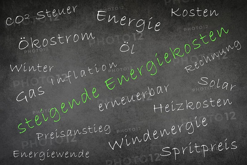 Words like increasing energy costs, fuel price, green electricity are standing on a chalkboard, german language