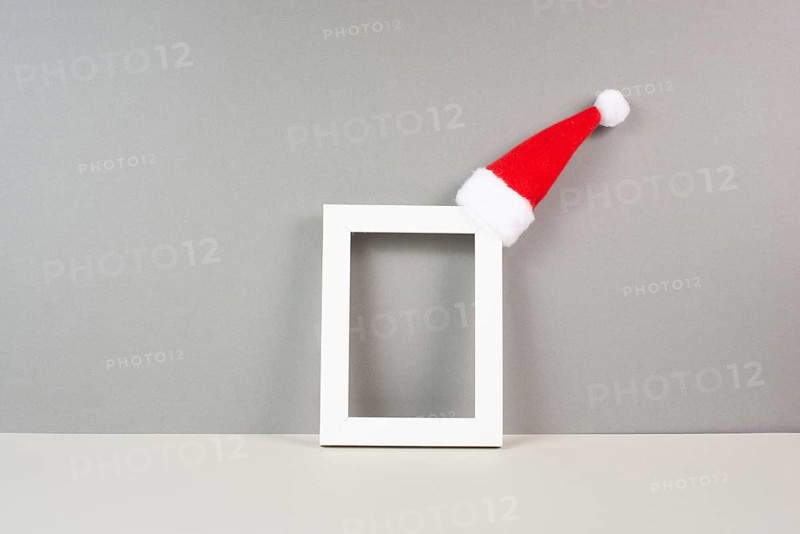 Home interior poster mock up with wooden frame, a red Santa Claus hat, greeting card for christmas, copy space for text and pictures