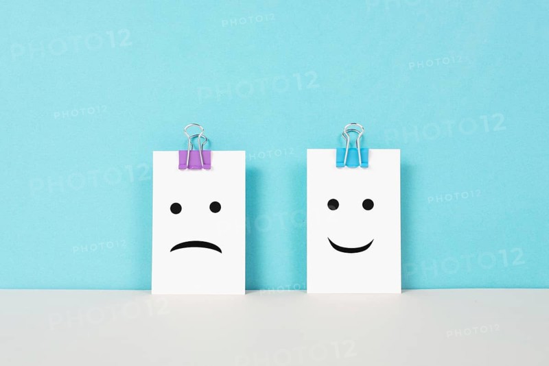 Head with a sad and a happy face, mental health concept, positive and negative mindset, depression, support and evaluation symbol, emotion