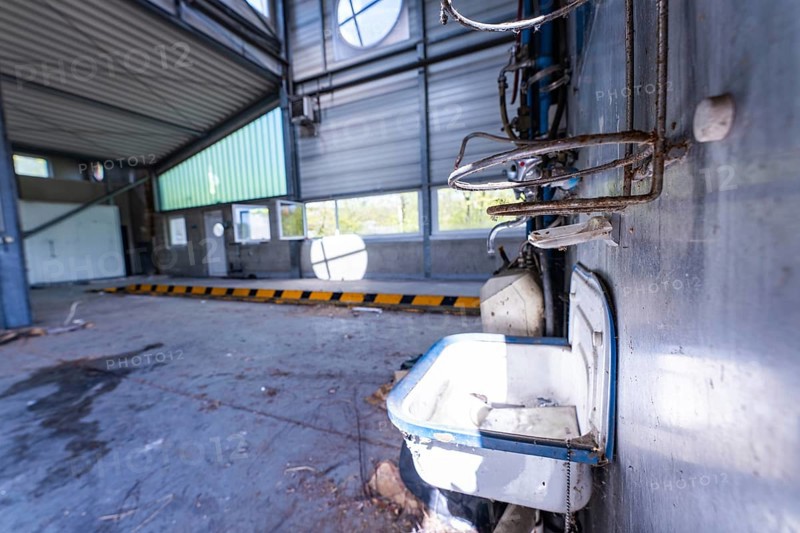 Abandoned hall with metal walls and an old washbasin in the foreground, demolition site, Saarbrücken, Germany, Europe