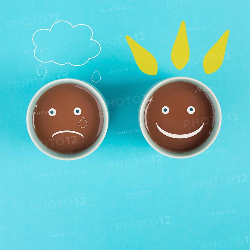 Cup of coffee with a sad and a happy face, positive and negative mindset, support and evaluation concept