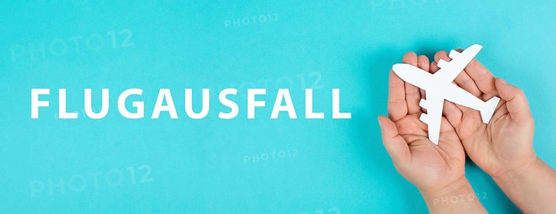 The word flight cancellation is standing in german language on the paper, staff shortage at the airport, vacation delayed