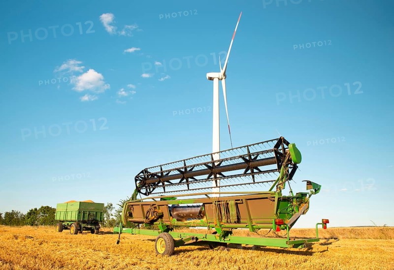 Harvester in a field of cultivated barley in Germany, harvest in the summer, agriculture for food, farmland on the countryside