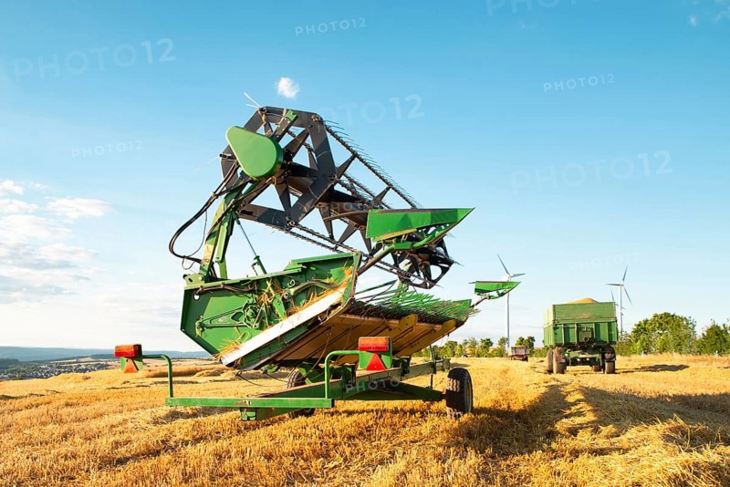 Harvester in a field of cultivated barley in Germany, harvest in the summer, agriculture for food, farmland on the countryside