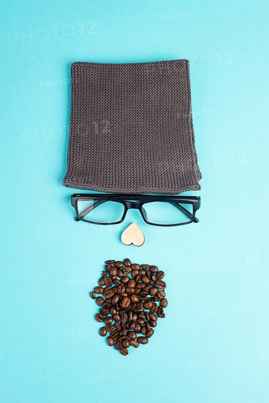 Human face made with a wool hat, glasses and coffee beans as a beard, funny minimalist portrait, eco freak lifestyle, having breakfast, taking a break