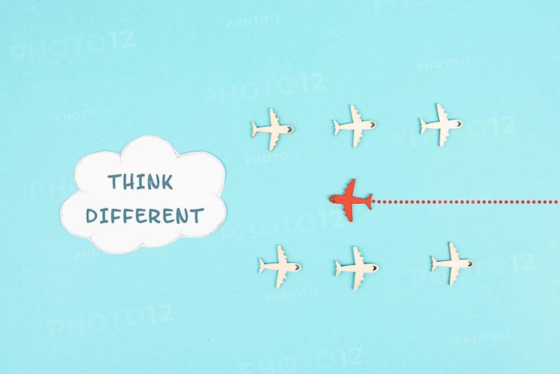Group of airplanes flying, red plane thinks different and takes the opposite direction, against the stream symbolic, courage and winner concept