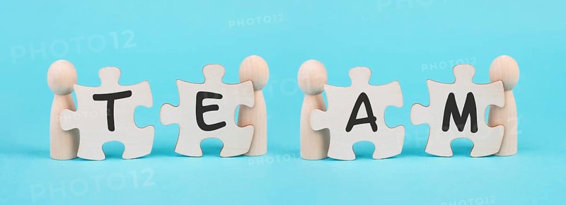 The word team is standing on puzzle pieces, connect the parts together, corporate in teamwork, communication and support concept