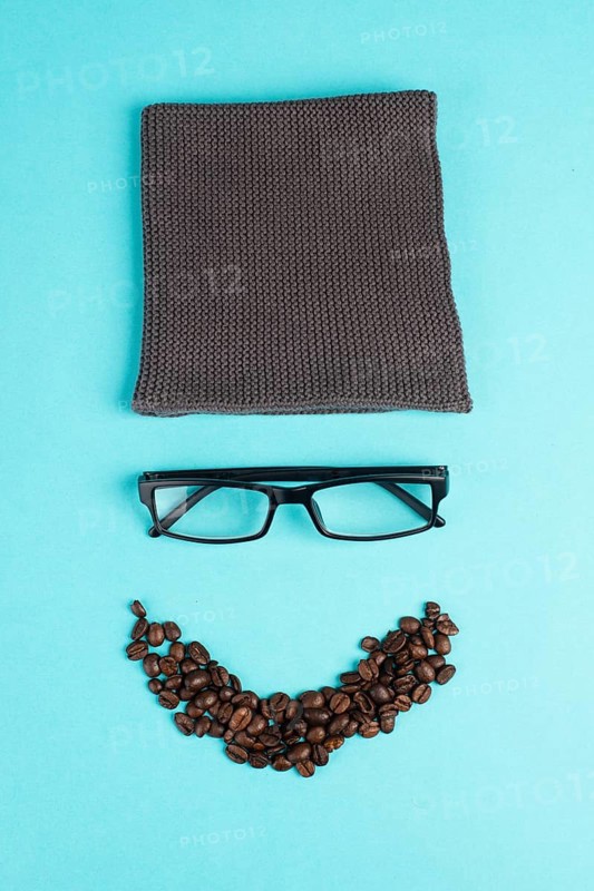 Human face made with a wool hat, glasses and coffee beans as a beard, funny minimalist portrait, eco freak lifestyle, having breakfast, taking a break