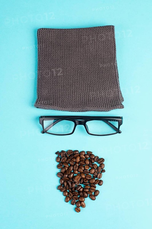 Human face made with a wool hat, glasses and coffee beans as a beard, funny minimalist portrait, eco freak lifestyle, having breakfast, taking a break