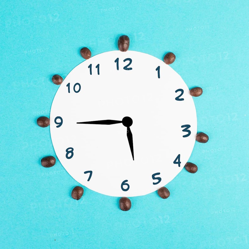 Alarm clock with numbers and coffee beans, wake up in the morning, having a deadline, time for a break, minimalistic concept, blue background