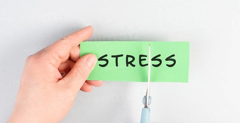 The word stress is standing on a paper, cutting the word with scissors, burnout concept, work life balance, breakdown by exhaustion