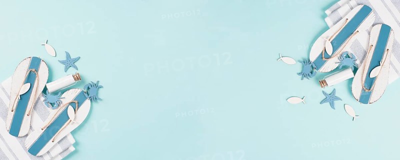 Blue colored summer and holiday background, flip flops, sea stars and a glass bootle with copy space, travel and tourism concept