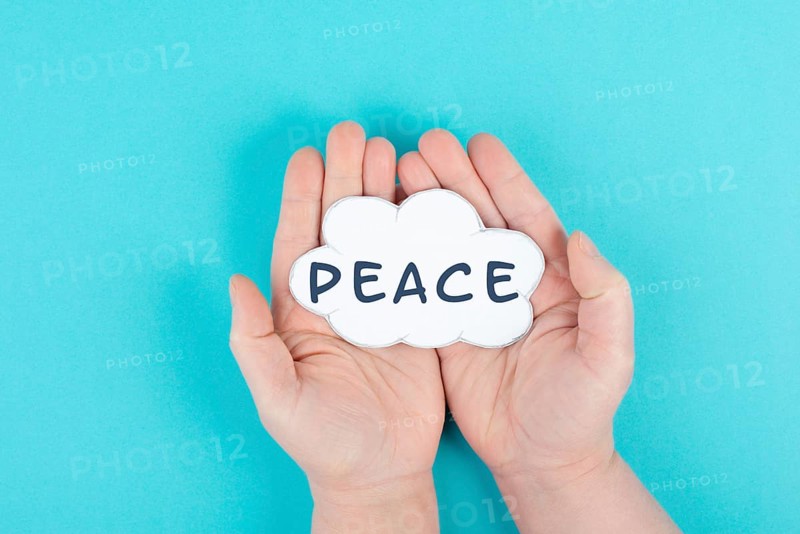 Holding a cloud with the word peace in the hands, stop war, support, living peaceful together