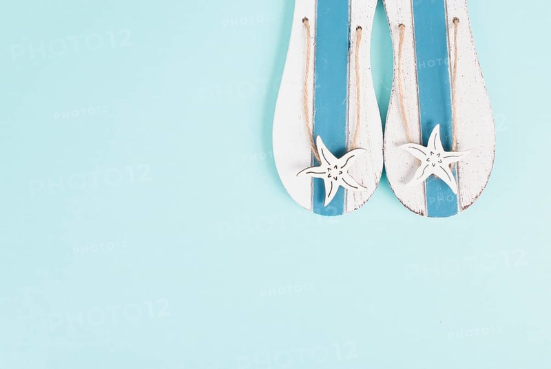Blue colored summer and vacation background, slippers with sea stars, copy space for text, holiday and tourism concept