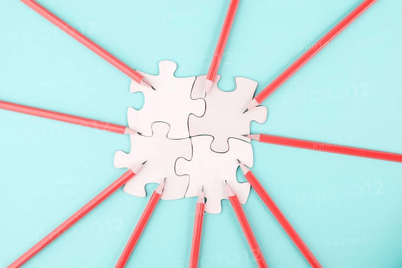 Working as a team, puzzle pieces connect together, pencils point to the jigsaw, brainstorming for ideas, business and education concept