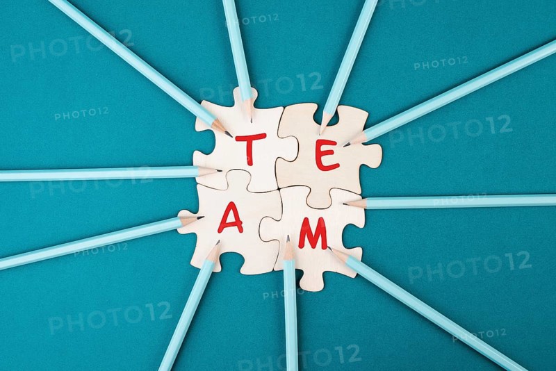 Working as a team, puzzle pieces connect together, pencils point to the jigsaw, brainstorming for ideas, business and education concept