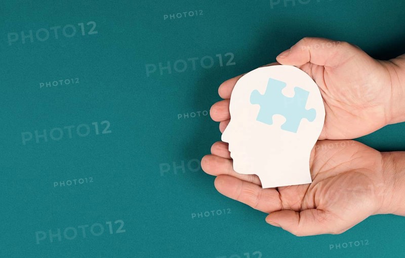 Holding a head with a puzzle piece, mental disease like Autism, Alzheimer, stroke awareness, brainstorming for ideas, memory problems