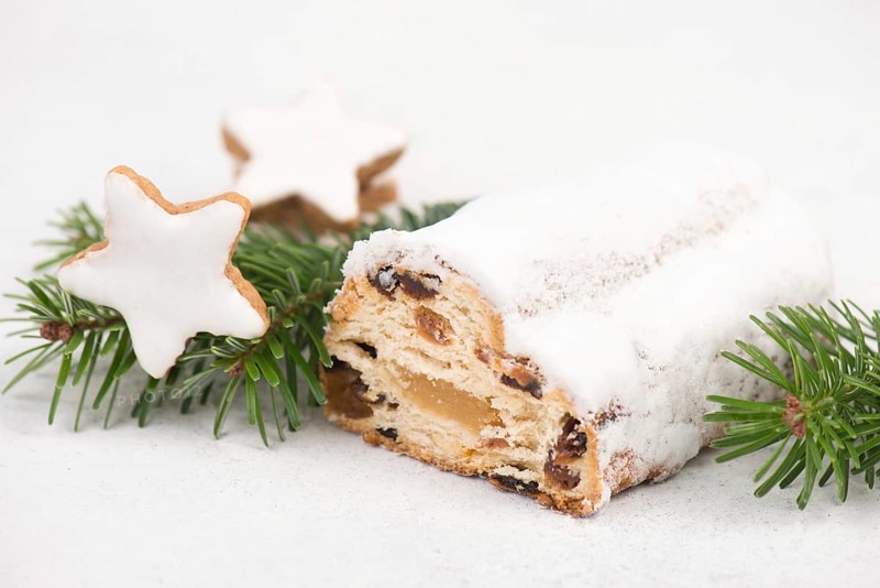 Christstollen, traditonal christmas cake with nuts, raisons, marzipan on a blue background, empty space for text