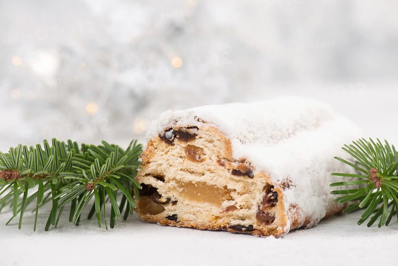 Christstollen, traditonal christmas cake with nuts, raisons, marzipan on a blue background, empty space for text