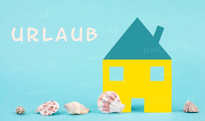 Colorful house on a blue colored background with sea shells, booking an appartment, hotel or lounge for vacation, holidays in summer on the beach, copy space for text