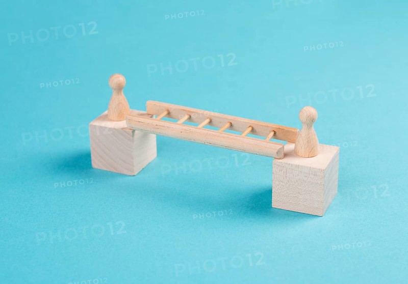 Two people connect by a ladder, buliding a bridge between men, separation and connection concept, meeting to overcome boundaries