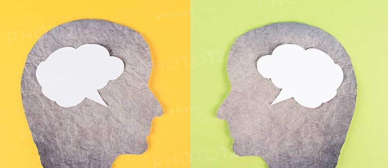 Silhouette of two faces, speech bubble in white color, copy space for text, communication, having an opinion and discussion, free speech, people talking, green yellow background