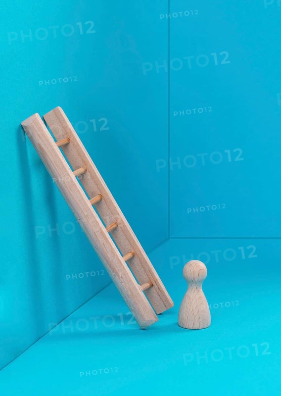 Man is standing next to a ladder, climbing up in career, having a goal, brainstorming for ideas, success strategy, taking a challenge, business concept