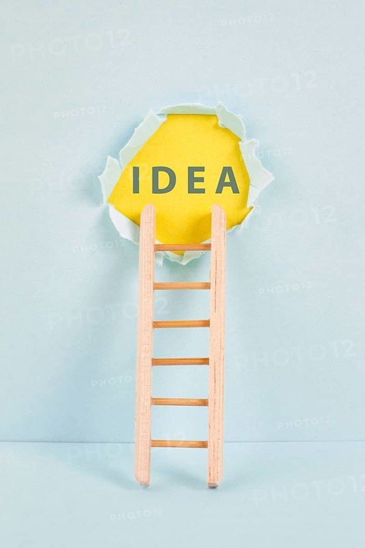 Ladder of success, having an idea, marketing and business concept, brainstorming for new goals, light bulb around torn paper