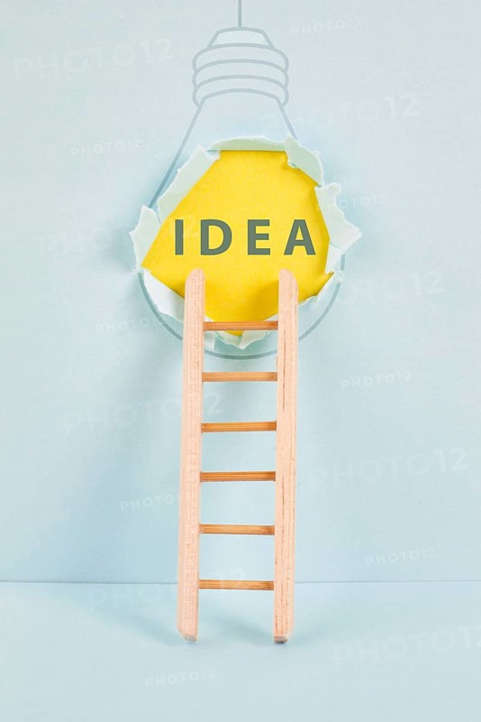 Ladder of success, having an idea, marketing and business concept, brainstorming for new goals, light bulb around torn paper