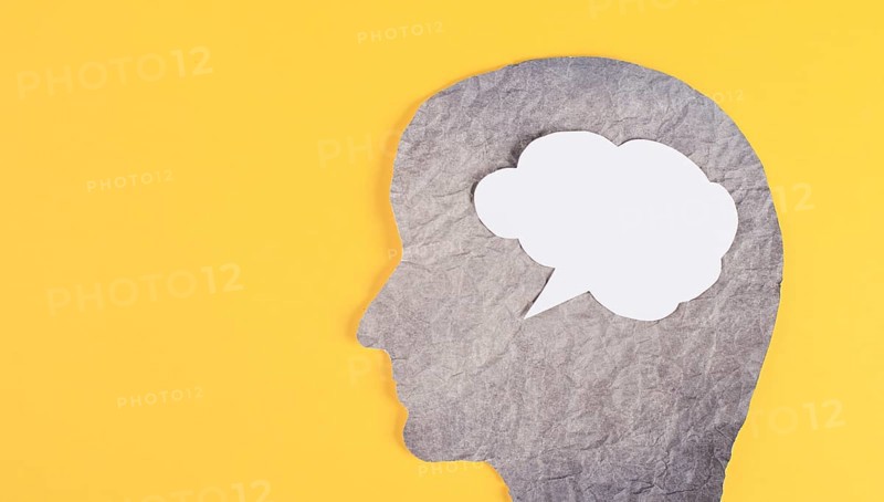 Silhouette of a face, speech bubble in white color, copy space for text, communication, having an opinion, free speech, people talking, yellow background