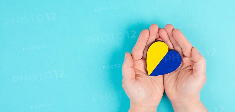 Holding a heart with the flag of Ukraine, national idendity, war crisis between Ukraine and Russia, political issue, isolated background