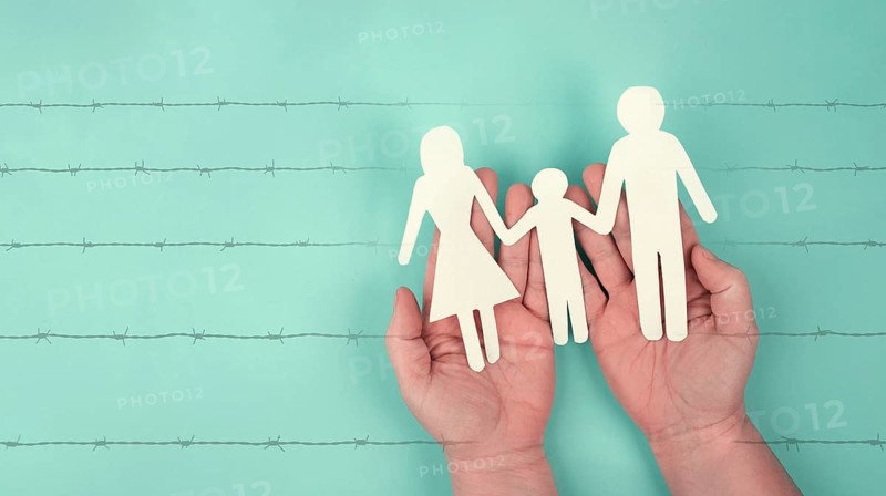 Immigration, refugees from Ukraine, asylem seekers, immigrants, silhouette of a family behind a barbed wire, border, human rights, russian conflict