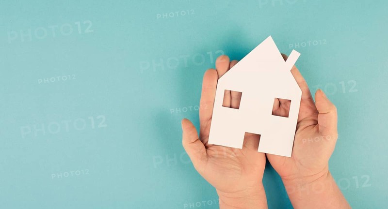 Holding a small paper house in the hands, planing a new home, real estate, owning property