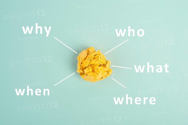 Crumpled up yellow paper on a bluec olored background, brainstorming, new idea, why, what, who