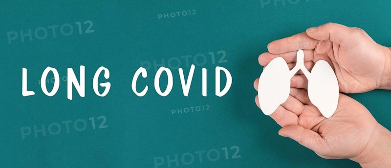 The words long covid are standing on a paper, hands hold a lung, breathing problems after Covid-19 disease