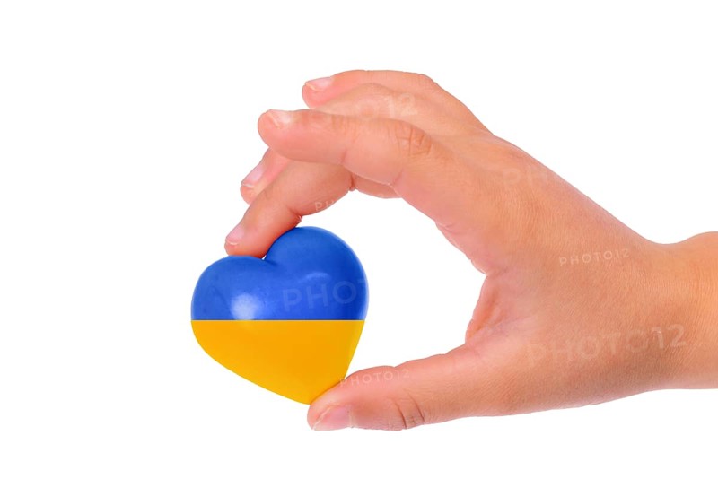 Holding a heart with the flag of Ukraine, national idendity, war crisis between Ukraine and Russia, political issue, isolated background
