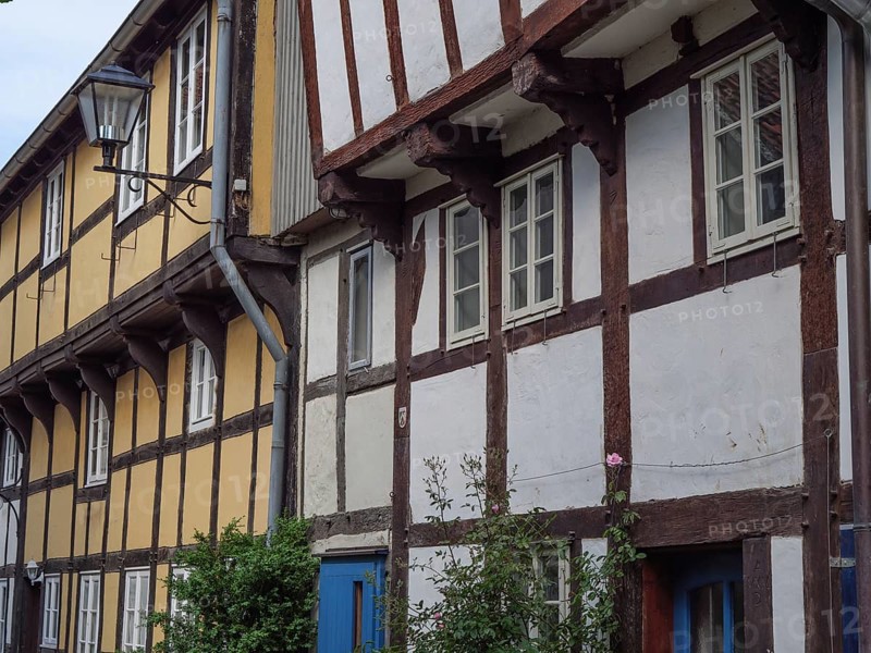 Traditional half-timbered houses with a street lamp and flowers on the facades, Detmold, North Rhine-Westphalia, Germany, Europe