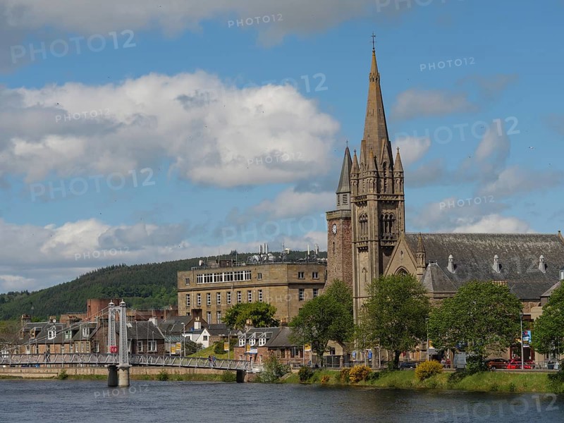 Large church tower and municipal buildings next to a bridge over a river with blue sky and clouds, inverness, scotland, Great Britain