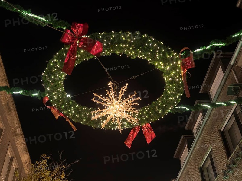 Illuminated Christmas wreath with lights and decoration above a street at night, bocholt, Münsterland, North Rhine-Westphalia, Germany, Europe