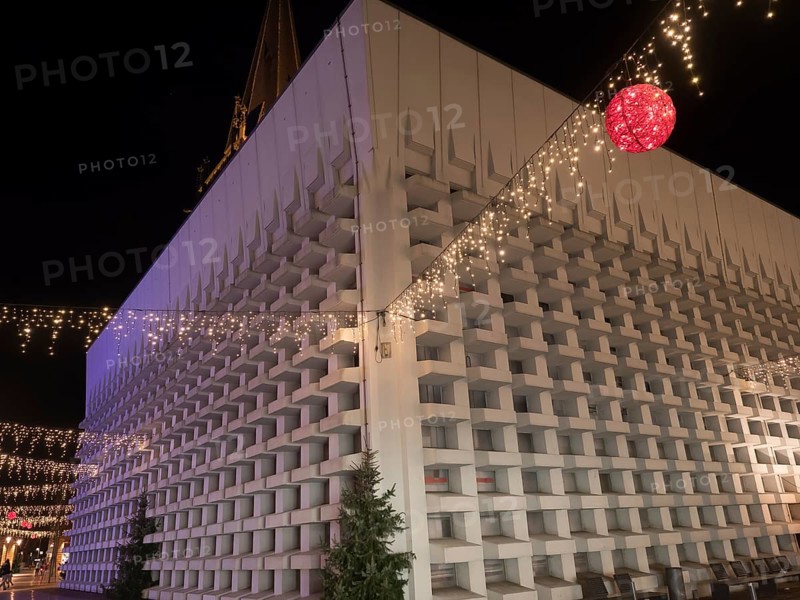 A modern building with Christmas decorations and fairy lights, suspended red ball, at night, Ahaus, Münsterland, North Rhine-Westphalia, Germany, Europe