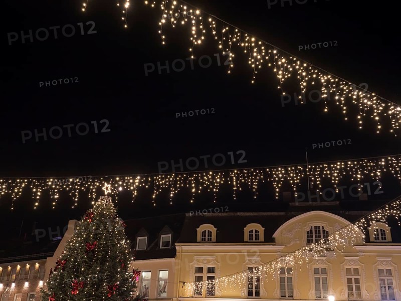 Atmospheric Christmas scene with fairy lights over a square and a Christmas tree in front of it, Ahaus, Münsterland, North Rhine-Westphalia, Germany, Europe