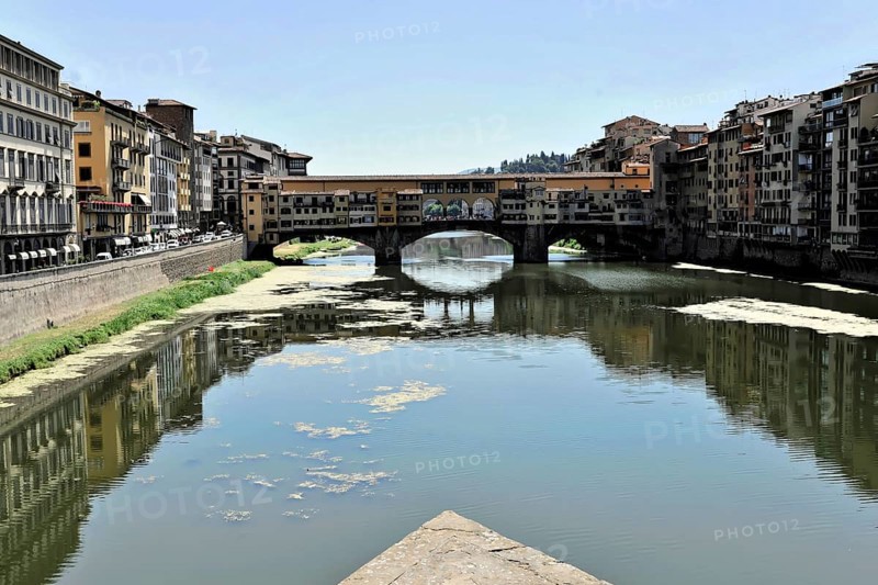 Buildings along the river Arno with Ponte Vecchio, Florence, Tuscany, Italy, Europe, A historic bridge over a tranquil river, reflected in the water under a clear sky, Europe