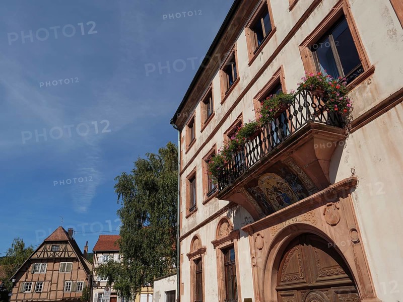 Historic building with balcony and flower boxes under a blue sky in a town, Wissembourg, Alsace, France, Europe