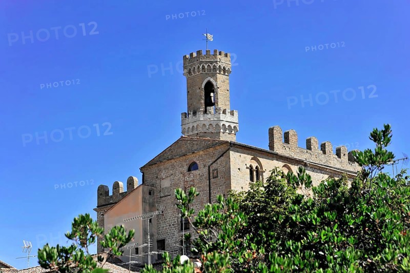 Volterra, Tuscany, Italy, Europe, A medieval castle with a high tower under a blue sky, surrounded by green vegetation, Europe