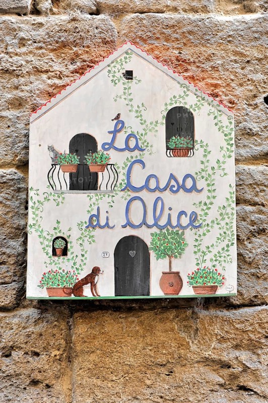 Volterra, Tuscany, Italy, Europe, Decorative hand-painted sign 'La Casa di Alice' on a stone wall with plant motifs and a dog, Europe